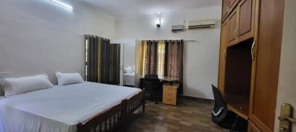 Bright and comfortable guest bedroom with neat interiors at Chavara Garden Homestay.